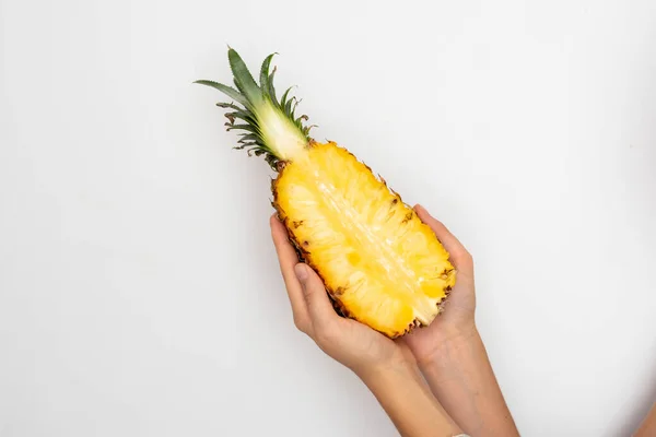 Mano femminile che tiene mezza ananas maturo su uno sfondo bianco . — Foto Stock