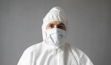 Beyaz koruyucu giysili doktor, tıbbi maske ve lastik eldivenler koronavirüs salgını tehdidi altındayken insanlara yardım etmeye hazır. Salgın, Coronavirus covid 19 salgını. Solunum cihazındaki doktor..