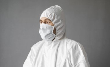 Beyaz koruyucu giysili doktor, tıbbi maske ve lastik eldivenler koronavirüs salgını tehdidi altındayken insanlara yardım etmeye hazır. Salgın, Coronavirus covid 19 salgını. Solunum cihazındaki doktor..