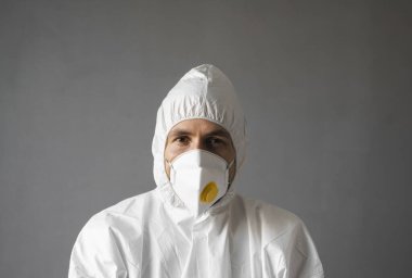 Beyaz koruyucu giysili doktor, tıbbi maske ve lastik eldivenler koronavirüs salgını tehdidi altındayken insanlara yardım etmeye hazır. Salgın, Coronavirus covid 19 salgını. Solunum cihazındaki doktor..