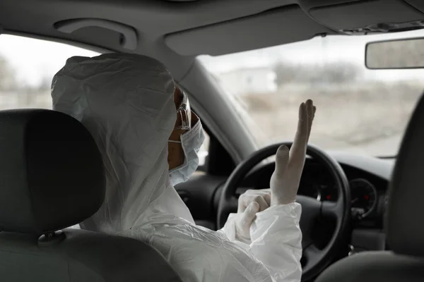 保護スーツの男、細菌やウイルスから保護するための医療用マスクとゴム手袋は運転する予定です。隔離中の保護マスク世界的大流行covid 19コロナウイルス感染. — ストック写真