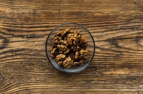 Nuez en un plato pequeño sobre una mesa de madera vintage como fondo. Las nueces son un alimento nutritivo saludable a base de proteínas vegetarianas. Snacks de frutos secos naturales . — Foto de Stock