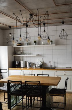 Lüks bir evde paslanmaz çelik aletlerle modern, parlak, temiz bir mutfak. Lüks malikanedeki mutfak. Modern mimari çağdaş, iç mimari. Şık mutfaklar. İçi masalarla dolu..