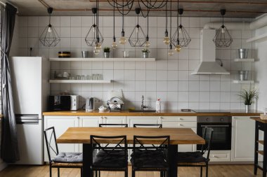 Lüks bir evde paslanmaz çelik aletlerle modern, parlak, temiz bir mutfak. Lüks malikanedeki mutfak. Modern mimari çağdaş, iç mimari. Şık mutfaklar. İçi masalarla dolu..