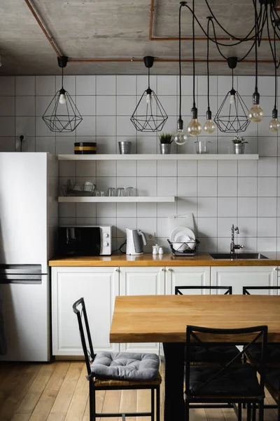 Lüks bir evde paslanmaz çelik aletlerle modern, parlak, temiz bir mutfak. Lüks malikanedeki mutfak. Modern mimari çağdaş, iç mimari. Şık mutfaklar. İçi masalarla dolu.. — Stok fotoğraf