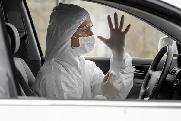 保護スーツの男、細菌やウイルスから保護するための医療用マスクとゴム手袋は運転する予定です。隔離中の保護マスク世界的大流行covid 19コロナウイルス感染. — ストック写真