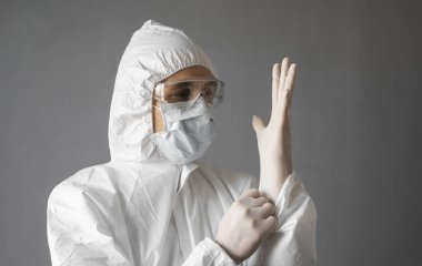 Beyaz koruyucu giysili doktor, tıbbi maske ve lastik eldivenler koronavirüs salgını tehdidi altındayken insanlara yardım etmeye hazır. Salgın, Coronavirus covid 19 salgını. Solunum cihazındaki doktor..