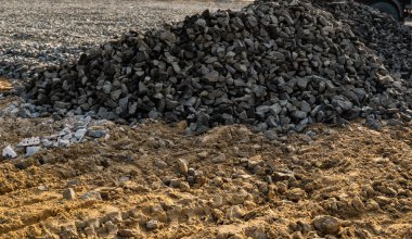 İnşaat alanında çakıl ve kum yığınları. İnşa için malzemeler.