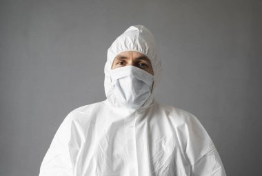 Beyaz koruyucu giysili doktor, tıbbi maske ve lastik eldivenler koronavirüs salgını tehdidi altındayken insanlara yardım etmeye hazır. Salgın, Coronavirus covid 19 salgını. Solunum cihazındaki doktor..