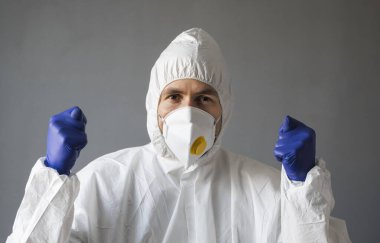 Beyaz koruyucu giysili doktor, tıbbi maske ve lastik eldivenler virüse işaret ediyor. Koronavirüs salgını tehdidi altındayken insanlara yardım etmek. Salgın, Coronavirus covid 19 salgını..