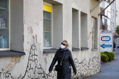 UKRAINE, KYIV - 25 Nisan 2020: Corona virüsü veya Covid 19 salgınını önlemek için tıbbi maske takan kadın.