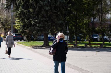 UKRAINE, KYIV - 25 Nisan 2020: Corona virüsü veya Covid 19 salgınını önlemek için tıbbi maske takan kadın.