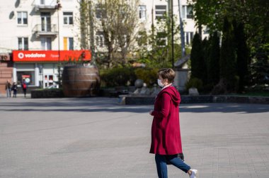 UKRAINE, KYIV - 25 Nisan 2020: Corona virüsü veya Covid 19 salgınını önlemek için tıbbi maske takan kadın.
