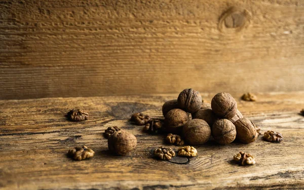 Καρύδι διάσπαρτα στο ξύλινο vintage τραπέζι. Τα καρύδια είναι μια υγιεινή χορτοφαγική πρωτεΐνη θρεπτική τροφή. Καρύδι σε ρουστίκ παλιό ξύλο. — Φωτογραφία Αρχείου