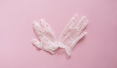 Lastik eldivenler pembe arka planda yatar. Covid-19 'a karşı anti-virüs koruma kiti. Coronavirus salgını 2019.