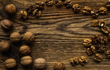 Ceviz, ahşap vintage masaya saçılmış. Ceviz sağlıklı bir vejetaryen protein besleyici gıdadır. Köhne odunda ceviz.