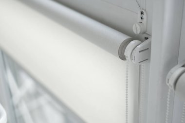 Oturma odasındaki ahşap desenli plastik camdaki beyaz kumaş silindirlerin ayrıntıları..