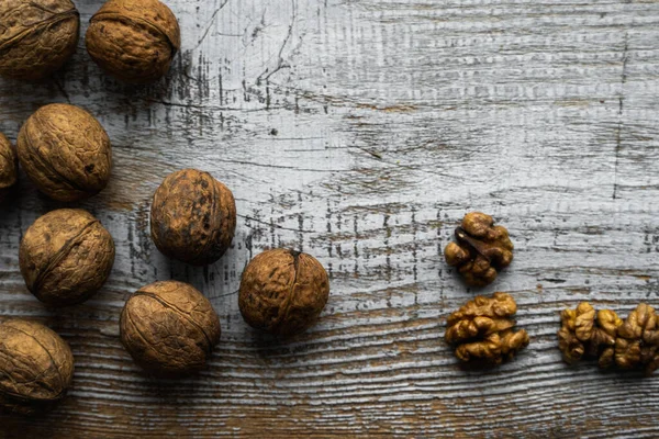 Noz espalhada na mesa vintage de madeira. Nozes é uma proteína vegetariana saudável alimento nutritivo. Noz em madeira velha rústica. Espaço de cópia . — Fotografia de Stock