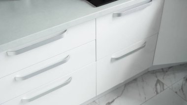 Konforlu bir mutfağın üzerinde beyaz, yaldızlı mutfak cepheleri. Modern beyaz mutfak temiz iç tasarım.