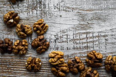 Ceviz, ahşap vintage masaya saçılmış. Ceviz sağlıklı bir vejetaryen protein besleyici gıdadır. Köy ahşabında ceviz. Boşluğu kopyala.