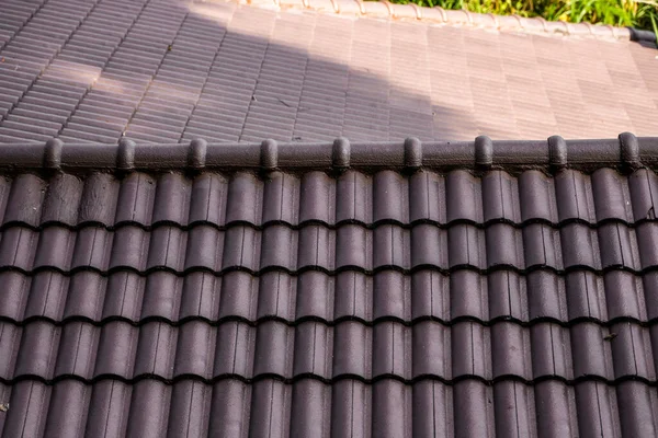 Barna természetes cserép tető. Modern tetőfedő anyagok. A ház teteje, természetes tetőcserép a kék ég ellen. Épület. — Stock Fotó