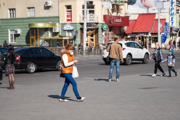 UCRANIA, KYIV - 25 de abril de 2020: Mujer con máscara médica para prevenir la infección bacteriana El virus Corona o la epidemia de Covid 19 caminando por la calle . — Foto de Stock