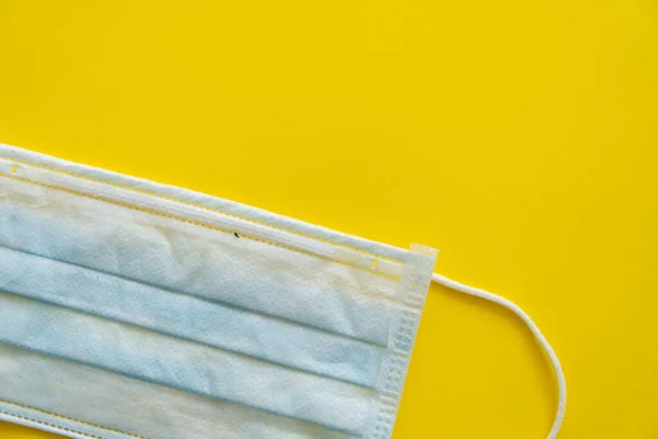 Blauw medisch beschermend masker geïsoleerd op gele achtergrond. Wegwerp 3-laags medisch masker om de mond en neus te bedekken om coronavirus te voorkomen. Procedure masker van bacteriën. Quarantaine van het coronavirus. — Stockfoto