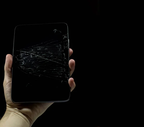 Tablet with a broken screen on a black background.