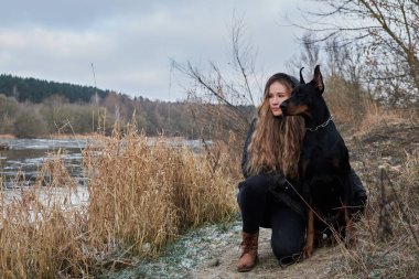 doberman köpeği olan güzel kadın portresi. Sıcak doğal renk.