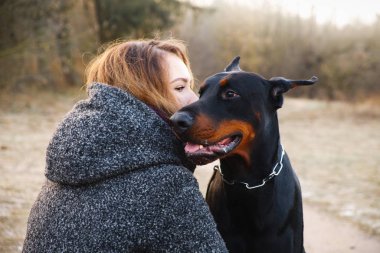 doberman köpeği olan güzel kadın portresi. Sıcak doğal renk.