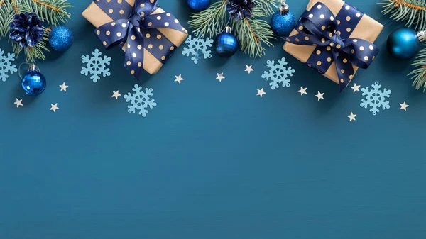 Klasik Noel çerçevesi sınırı. Mavi arka planda üç köknar, mavi toplar ve kar taneleri yatıyordu. Üst görünüm, boşluğu kopyala. Yeni yıl tebrik kartı şablonu, Xmas kartpostal modeli.