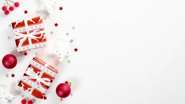 Κομψό κόκκινο και λευκό χριστουγεννιάτικα δώρα και διακοσμήσεις σε λευκό φόντο. Επίπεδο lay, πάνω όψη, αντιγραφή χώρου. Χειμερινές διακοπές ευχετήρια κάρτα mockup, Χριστούγεννα πλαίσιο συνόρων, το νέο έτος πρότυπο πανό — Φωτογραφία Αρχείου