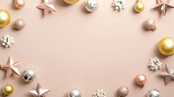 Vánoční rám z elegantních vánočních ozdob, zlaté a stříbrné kuličky, růžové hvězdy na pastelovém slonovinovém pozadí. Šablona blahopřání, pozvánka na vánoční večírek s kopírovacím prostorem. — Stock fotografie