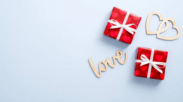 해피 발렌타인데 이 컨셉. Gift wrapper red paper, wooden text sign Love and heart shape on blue background. 위에서 내려다 본 평평 한 모습. — 스톡 사진