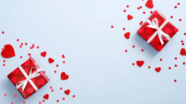 Conceito do Dia dos Namorados. Caixas de presente embrulhado papel vermelho e corações em fundo azul. Flat lay, vista superior, espaço de cópia . — Fotografia de Stock