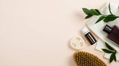 Bej arka planda organik kozmetik ürünler seti. Yağ şişesi, losyon, spa fırçası, luffa süngeri, havlu. Banyo için doğal organik güzellik ürünü