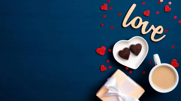 발렌타인데이 깃발. Flat lay gift box, coffee cup, heart shaped candy, wooden text sign Love on blue background. 사랑 과 로맨스 개념. — 스톡 사진