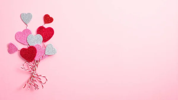 Серця Валентина виглядають як повітряні кулі на рожевому тлі. Плоский простір, вид зверху. Концепція любові і романтики — стокове фото