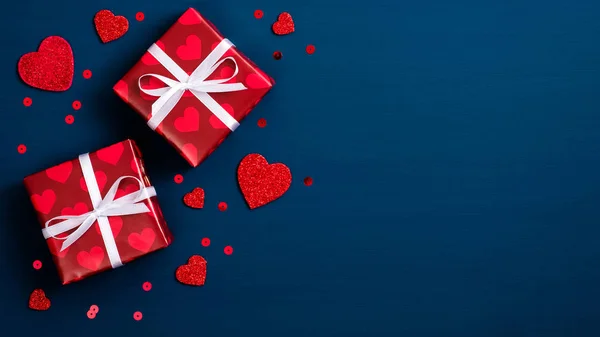 Fondo de San Valentín con cajas de regalo rojas y corazones en azul. Asiento plano, vista superior. Concepto de amor y romance . — Foto de Stock
