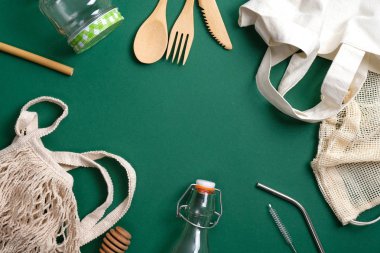 Çevre dostu bambu çatal bıçak takımı, tekrar kullanılabilir tuval alışveriş torbası, cam kavanoz ve şişe, sicim torbası, metal pipet. Sıfır atık, plastiksiz konsept. Sürdürülebilir yaşam tarzı. Çevre mağazası afişi.