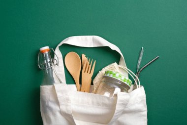 Çevre dostu, yeniden kullanılabilir bambu çatal bıçaklı, metal pipet, cam kavanoz ve şişe içeren alışveriş torbası. Sıfır atık, plastiksiz konsept. Sürdürülebilir yaşam tarzı