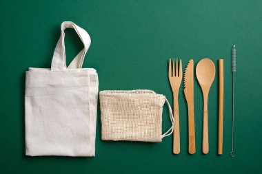 Sıfır atık, plastiksiz, çevre dostu bambu çatal bıçak seti ve yeniden kullanılabilir tuval alışveriş torbaları. Sürdürülebilir yaşam tarzı kavramı.
