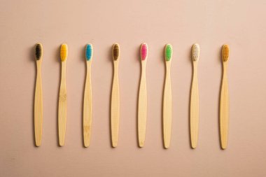 Kahverengi arka planda renkli bambu diş fırçaları. Sıfır atık, plastiksiz konsept. Düz yatış, üst görünüm.
