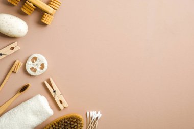 Kahverengi arka planda sıfır atık banyo öğesi vardı. Üst düzey el yapımı sabun, eko doğal bambu diş fırçaları, tahta raptiyeler, banyo fırçası ve havlu. Plastiksiz, çevre dostu organik ürün konsepti