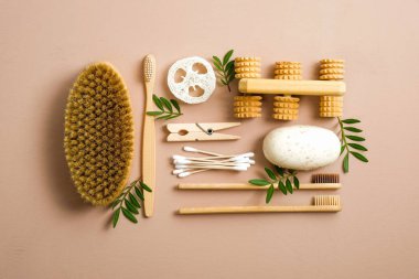 Sıfır atık banyo eşyası takımı. Düz eko doğal bambu diş fırçaları, banyo fırçası, luffa süngeri, ev yapımı sabun, kulak çubukları, yeşil yapraklar. Plastiksiz, çevre dostu organik ürün konsepti