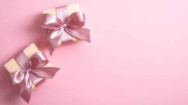 Pembe arka planda pembe kurdeleli iki hediye kutusu ve fotokopi alanı. Mutlu Kadınlar, Anneler Günü, Sevgililer Günü, doğum günü tebrik kartı tasarımı