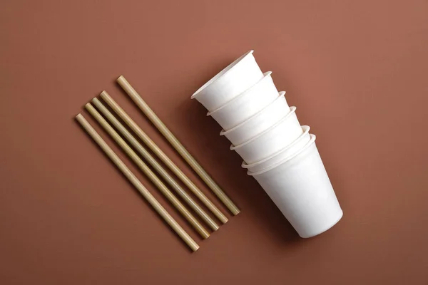 Paper cups and bamboo drink straws on brown background. Zero waste concept. Flat lay, top view. Plastic free sustainable lifestyle. — Stock Photo, Image