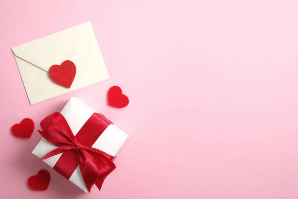 Carta romántica de amor y caja de regalo con cinta roja sobre fondo rosa con corazones de San Valentín. Piso tendido, vista superior, espacio para copiar. Feliz día de San Valentín concepto — Foto de Stock