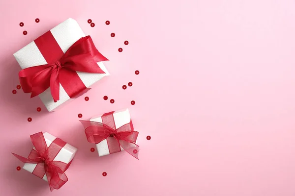 Cajas de regalo blancas con lazo de cinta roja sobre fondo rosa con confeti. Sorpresa del día de San Valentín, concepto de amor. Piso tendido, vista superior . — Foto de Stock