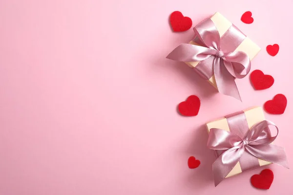 Cajas de regalo con cinta rosa y corazones rojos sobre fondo rosa. Piso tendido, vista superior, espacio para copiar. San Valentín, aniversario, día de la madre y tarjeta de felicitación de cumpleaños maqueta . — Foto de Stock